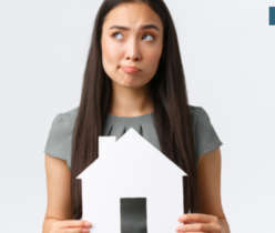 confused woman holding paper house